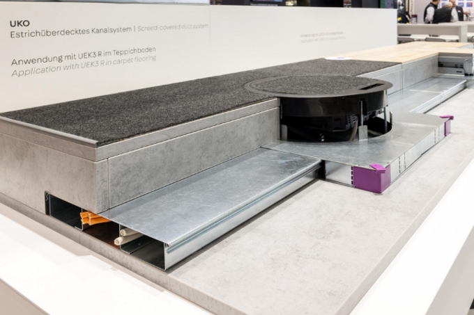 Sistema de canalización bajo suelo con recrecido UKO en oficina técnica, con cajas bajo suelo y distribución ordenada de energía y datos.