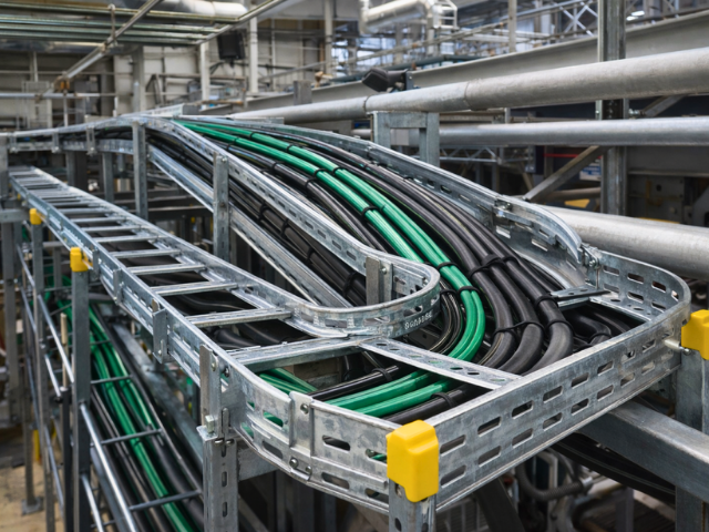Bandeja escalera para cables en instalación industrial con soportes y accesorios.