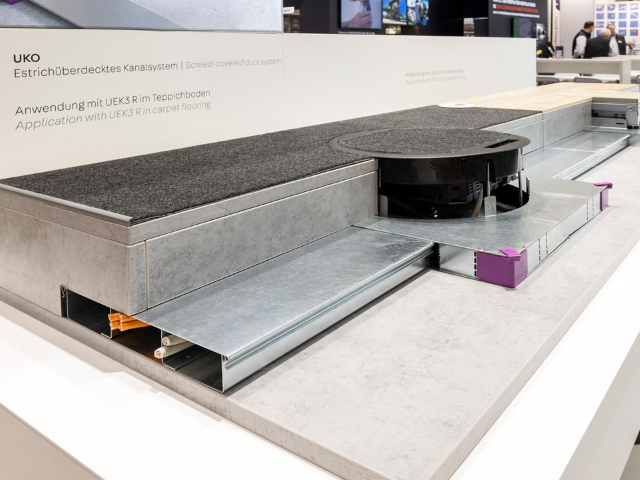 Sistema de canalización bajo suelo con recrecido UKO en oficina técnica, con cajas bajo suelo y distribución ordenada de energía y datos.